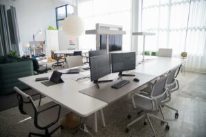 Empty office with a single computer screen illuminated, symbolising the unseen energy consumption of idle workplace technology.